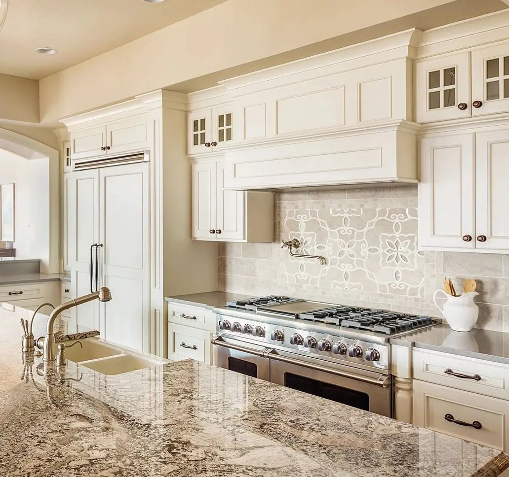 A kitchen with white cabinets and granite counter tops.