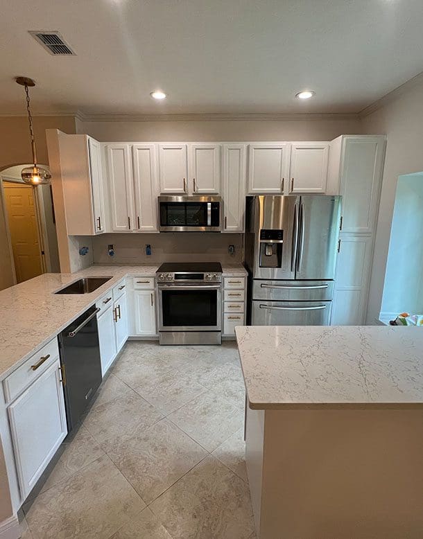 A kitchen with white cabinets and stainless steel appliances.