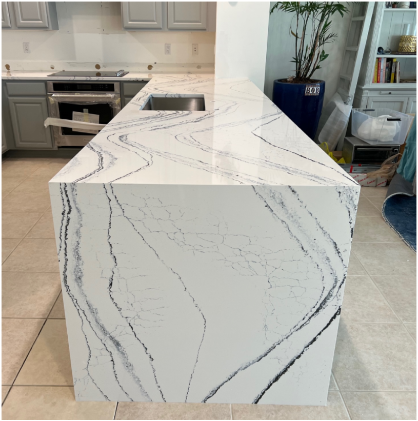 A kitchen with marble counter tops and tile floors.