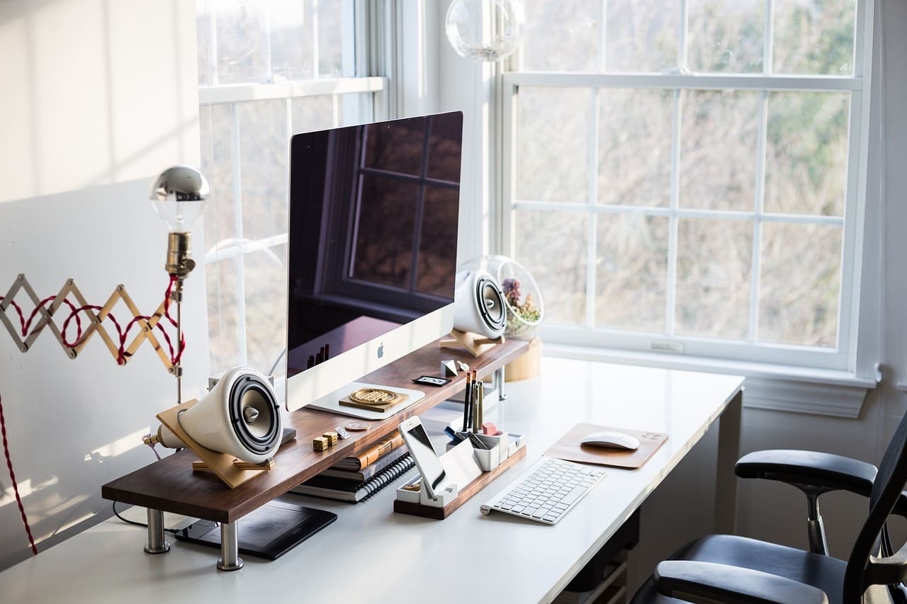 A desk with a computer and speakers on it